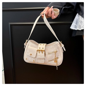 Detail of cream shoulder bag with golden star pendants and studded buckle accents
