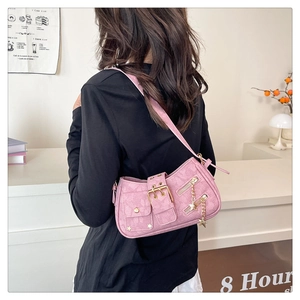Detail of pink shoulder bag featuring metallic star charm and studded motorcycle style