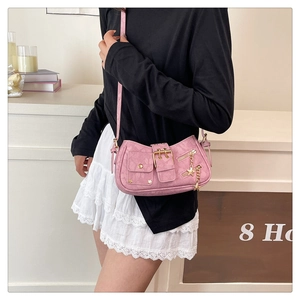 Close-up of pink Y2K shoulder bag featuring star charms and embossed leather texture