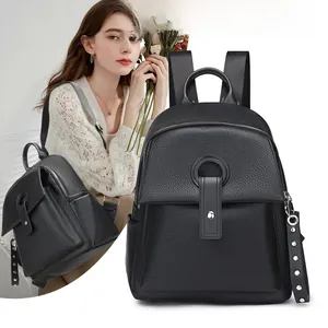 Close-up of black litchi pattern leather backpack with rivet straps and metallic buckles