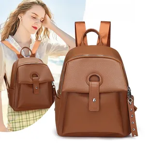 Macro shot of brown lychee grain backpack showing flap pocket and metal ring detail