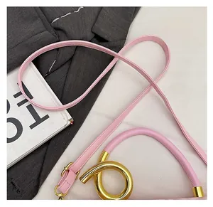 Detail of pink saddle bag featuring gold ring handle and soft lychee grain leather