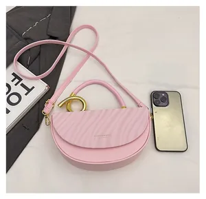 Pink crescent saddle bag detail showing wave pattern flap and metallic round buckle close-up