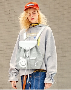 Detail of silver textured backpack with marble pattern and white flap and charm