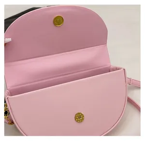 Detail view of pink saddle bag interior with dual magnetic gold hardware buckles
