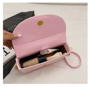 Spacious interior of pink semi-circle saddle bag with makeup and umbrella storage
