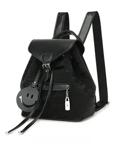 Detail view of the black nylon backpack with leather flap and iconic smiley charm