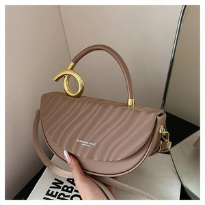 Detail of coffee saddle bag with wave texture and gold metallic knot handle buckle