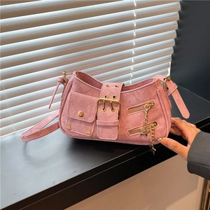 Pink rivet shoulder bag with golden star charms and multi-buckle strap on dark surface