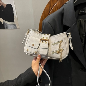 Y2K style beige rivet shoulder bag with metal stars and buckle straps in a fashion setting