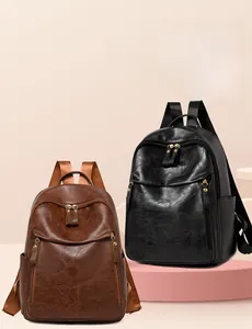Detail of vintage faux leather backpacks in brown and black with gold metal hardware