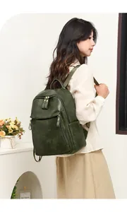 Detail of dark green vintage PU leather backpack with gold zippers shown on model