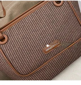 Close-up of woven texture and FASHION leather patch on dark brown tote bag