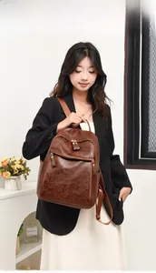 Detail view of vintage brown backpack with textured oil-leather finish and zipper pockets
