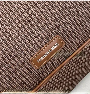 Macro view of dark coffee woven fabric and leather patch with silver lettering detail