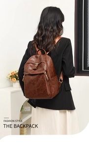Rear view of model wearing a vintage dark brown textured leather backpack with gold zippers