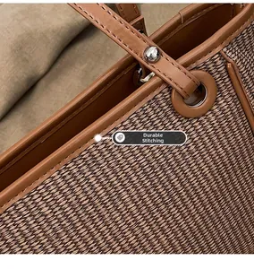 Close-up of precise stitching and silver rivets on the brown woven tote bag handle
