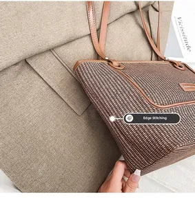 Close-up of woven tote bag texture with brown leather trim and metallic brand plaque