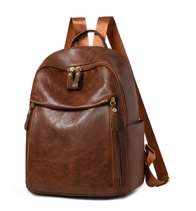 Detailed side view of the brown retro leather backpack with golden zippers and pockets