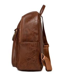 Side view of brown vintage PU leather backpack with pebble texture and adjustable straps