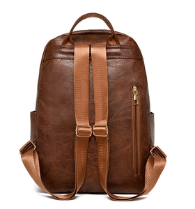 Detailed back view of brown leather backpack with adjustable straps and zipper pocket