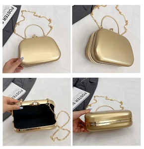 Detail of gold metal evening bag featuring a rhinestone clasp and removable chain strap