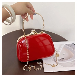 Detail of red patent leather evening bag with gold handle and crystal clasp closure