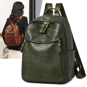 Close-up detail of vintage leather texture and multiple zipper pockets on backback