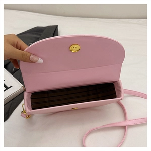 Close-up of pink mini flap bag interior with striped lining and gold magnetic snap