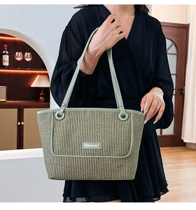 Detailed macro view of woven straw tote bag texture and light green leather handles