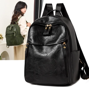 Close-up of litchi grain PU leather backpack with gold zippers in black and green