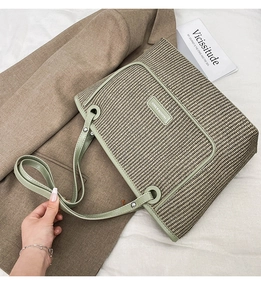 Detail view of woven tote bag with green leather trim and Fashion & Bags leather patch