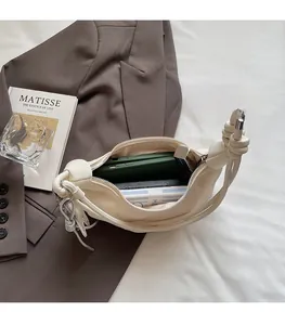 Detail showing the spacious interior of the pleated cream crescent shoulder bag
