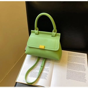 Dettaglio della borsa verde chiaro in pelle a grana con fibbia dorata e cuciture di pregio