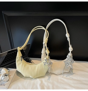 Detailed view of pleated shoulder bags with knotted straps and star balloon dog charms