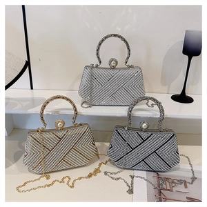 Detail of luxury rhinestone clutch bags with pearl clasp and metal ring handles