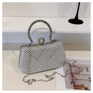 Detailed view of silver evening bag with faux pearl stripes and metallic woven handle