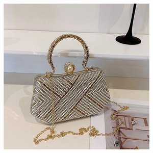 Detail of luxury gold dinner clutch with rhinestone geometric pattern and round handle