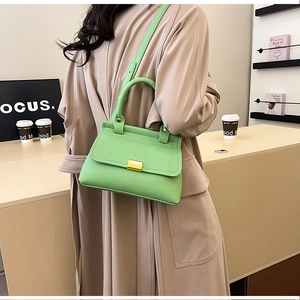 Dettaglio borsa in pelle verde lime con fibbia dorata e tracolla regolabile