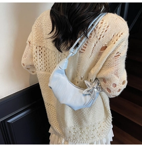 Close-up of light blue crescent bag with silver starfish metal charm and pleated texture