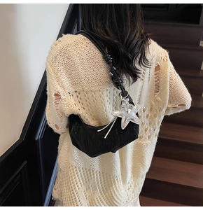 Detail of pleated black hobo bag featuring rope strap and shiny silver starfish charm