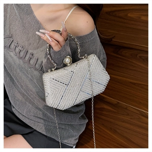 Detail of silver pearl evening bag with rhinestones, metal ring handle and chain strap