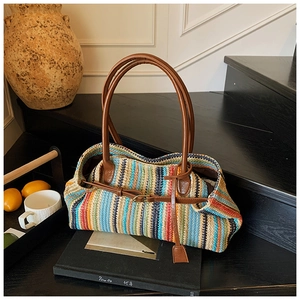 Detailed view of a multi-color striped woven tote bag with leather straps on vintage steps