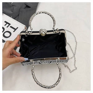 Detail of evening clutch featuring heart pearl clasp and sparkling rhinestone finish