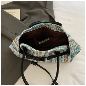 Detail view of woven tote bag with wavy patterns, leather straps and inner pocket