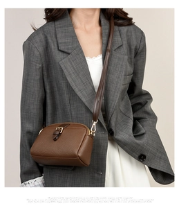 Close-up of soft brown lychee grain leather crossbody bag with elegant gold hardware
