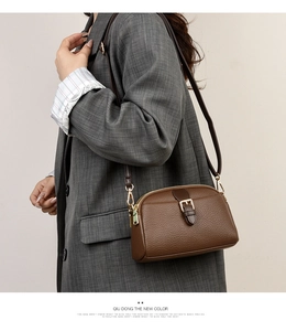 Side view of brown lychee grain leather crossbody bag with golden hardware on a model
