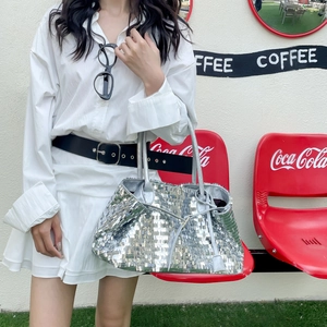 Silver sequin tote bag shown in a lifestyle street setting with double shoulder straps