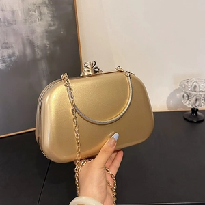 Elegant gold hard-shell evening clutch bag with rhinestone clasp and metal handle