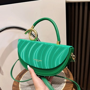 Chic emerald green saddle bag with wavy textured flap and gold hardware accents